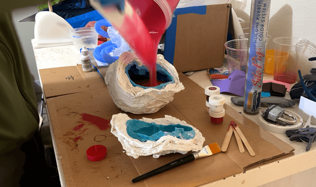 Filling the silicone/plaster mold with silicone in preparation to rotate cast