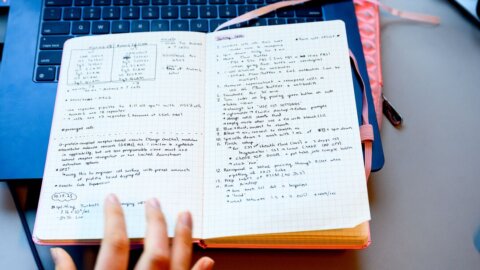 An open notebook filled with handwritten notes, showing various protocols being reviewed in the Lim Lab at UCSF’s Mission Bay campus