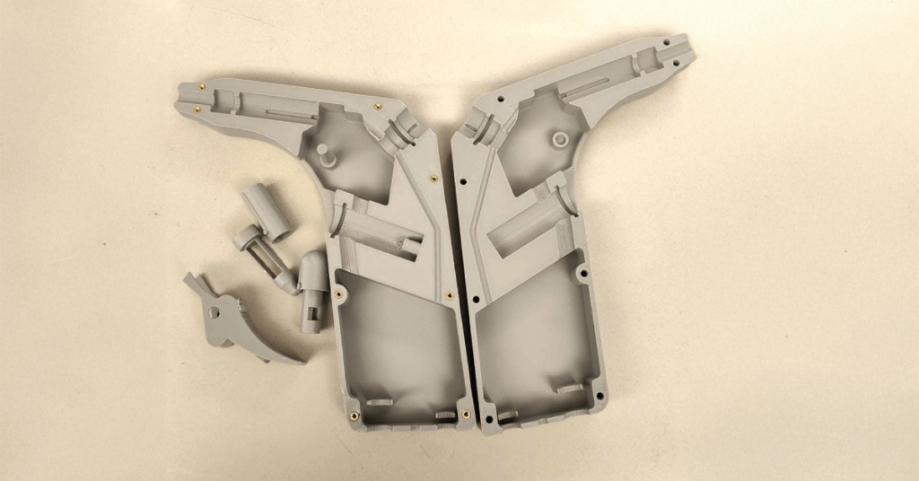 3D printed prototype of medical device in gray PLA against beige background