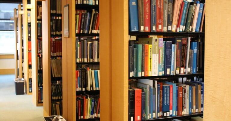 Rows of shelves lined with books in the Kalmanovitz Library.